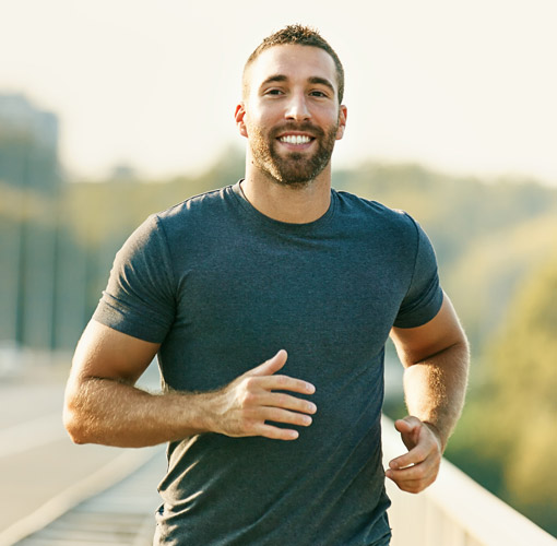 man smiling outside in t-shirt jogging
