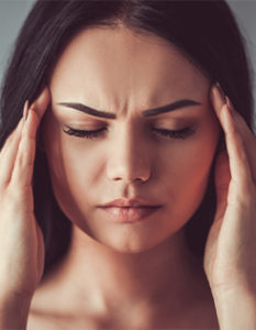 Woman rubbing her temples from a headache