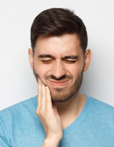 Man touching a sore jaw