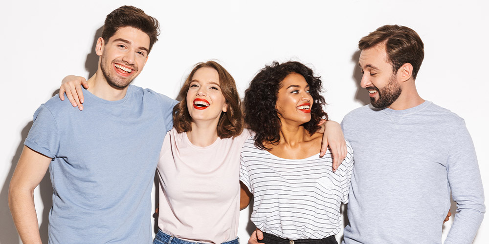 two men and two women standing next to each other smiling and laughing